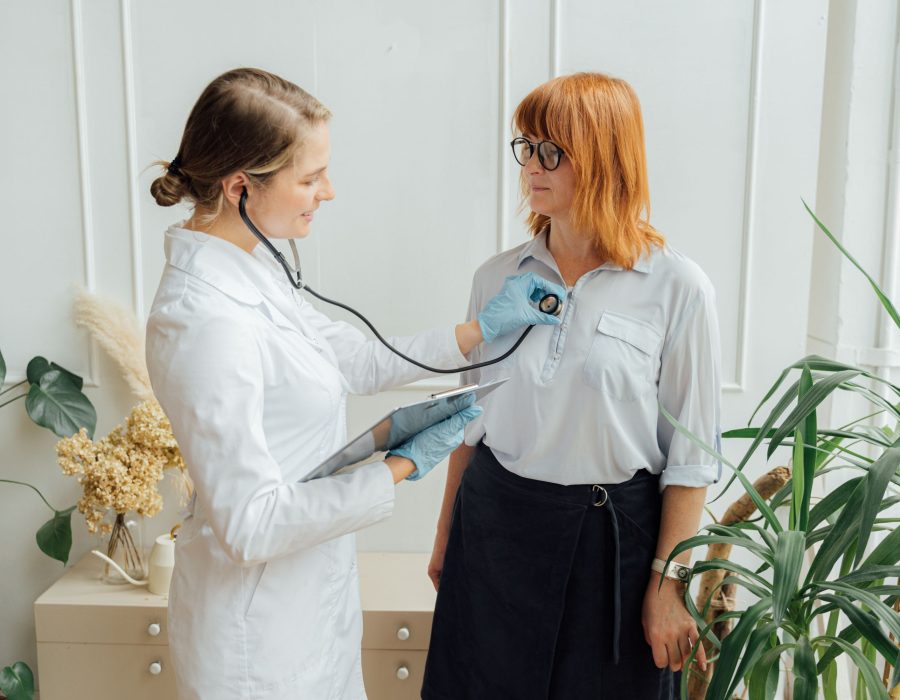 Ärztin untersucht eine Patientin mit dem Stethoskop